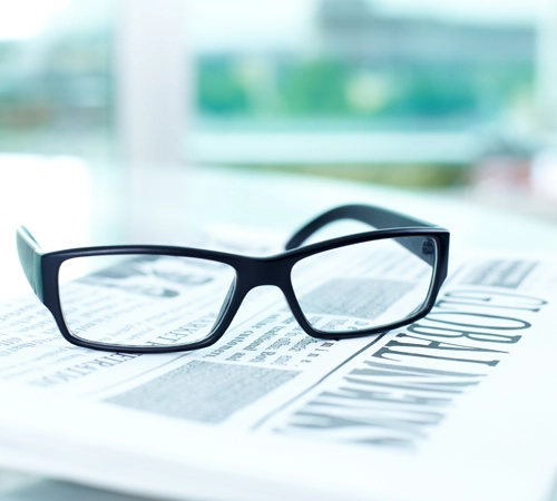 A close-up of a pair of glasses on a newspaper